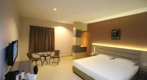 a hotel room with a bed and a table at Lovina Inn Hotel Batam in Batam Center