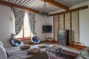 ヴァランスにあるMaison de la Praのベッドと椅子2脚とテレビのある寝室