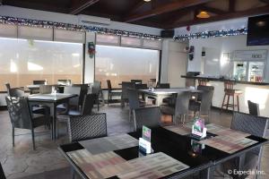 um restaurante com mesas e cadeiras em uma sala em Moonbay Marina the Villas em Olongapo