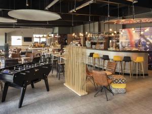 a restaurant with a bar with a pool table and chairs at Ibis Madrid Fuenlabrada in Fuenlabrada