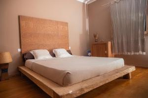 a bedroom with a large bed with a wooden headboard at Cocoa Beach Lodge sur Île Nosy Komba in Nosy Komba