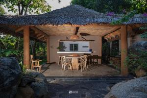 a pavilion with a table and chairs and a television at Cocoa Beach Lodge sur Île Nosy Komba in Nosy Komba