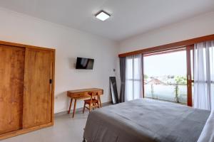 een slaapkamer met een bed, een bureau en een raam bij Casa Serena Cemagi in Canggu +11 foto's