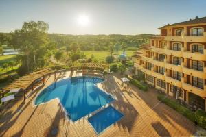 Una vista aérea de una piscina al lado de un edificio. en Ilunion Golf Badajoz, en Badajoz