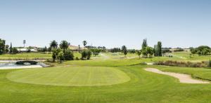 uitzicht op een golfbaan met een groen bij Ilunion Golf Badajoz in Badajoz