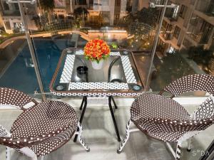 a table and chairs with a sink and a vase of flowers at Beer Home Apartment - Huế Free Pool and Gym in Hue