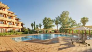una piscina frente a un edificio en Ilunion Golf Badajoz, en Badajoz