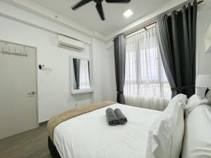 a bedroom with a bed with a pair of slippers on it at Troika Residence Kota Bharu by Sakama Homestay in Kota Bharu +25 photos