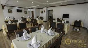 un salón de banquetes con mesas y sillas con servilletas en The Mou Hotel, en Phnom Penh