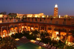 een uitzicht op een gebouw 's nachts met een klokkentoren bij Les Jardins De La Koutoubia in Marrakesh