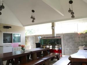 a dining room with wooden tables and a fish tank at Rommai Rimnaam Resort in Ban Bang Rin (1)