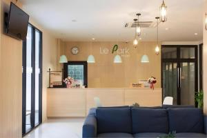 a living room with a blue couch and a counter at Le Park Hotel in Thung Song