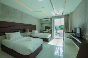 a hotel room with two beds and a television at Phuglong Hotel in Phayao +123 photos