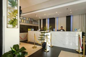 a man sitting at a reception desk in a lobby at Eighty Eight Hotel in Koronadal