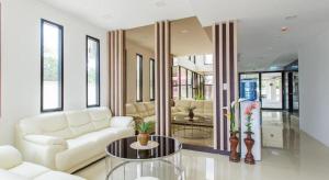 a living room with a white couch and a table at B2 Ubon Premier Hotel in Ban Nong Bua