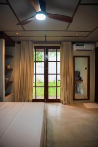 Un dormitorio con una cama y puertas corredizas de vidrio. en Bela Ahangama, en Ahangama