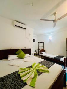 2 Betten in einem Zimmer mit grünen Handtüchern darauf in der Unterkunft Opera Tangalle in Tangalle