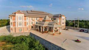 S-Tawan Hotel & Convention في مها ساراخام: مبنى مع شرفة في موقف للسيارات