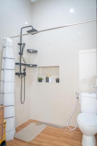 a bathroom with a shower and a toilet at Micko Homestay, Mantrijeron "Top Rated Value" in Yogyakarta +42 photos