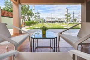 a patio with two chairs and a table with a plant at Smile Park Hotel in Ban Ba Ngan