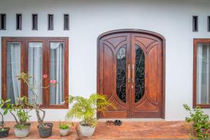 a wooden door on a house with potted plants at Micko Homestay, Mantrijeron "Top Rated Value" in Yogyakarta