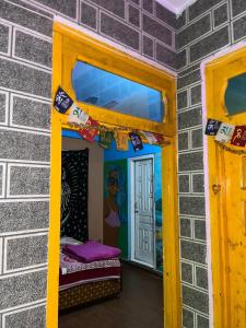 una stanza con una porta gialla e una parete con uno specchio di Royal Mount a Kasol