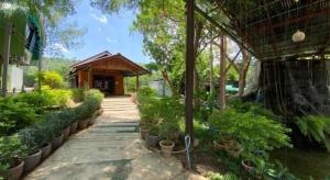 a garden with potted plants and a building at OYO 966 Boss Khaoyai in Ban Bung Toei