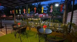 two tables and chairs with flowers on a patio at P Bliss Hotel in Phayao
