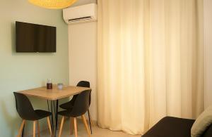 een eettafel met stoelen en een gordijn bij Résidence Luna, Saint-Cyprien in Porto-Vecchio