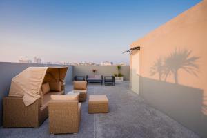 a patio with a couch and some chairs and a wall at hiii Aura Pool Villa Hotel Pattaya Central in Pattaya Central