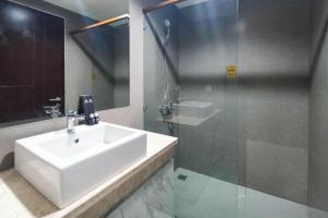 a bathroom with a sink and a glass shower at Apartment Amarta Studio with Living Room in Yogyakarta