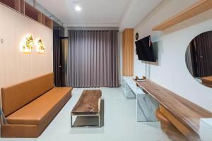 a living room with a couch and a tv at Apartment Amarta Studio with Living Room in Yogyakarta
