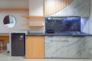 a kitchen with a sink and a counter top at Apartment Amarta Studio with Living Room in Yogyakarta