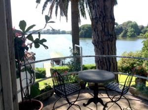 a balcony with a table and chairs and a tree at Villa sull'Acqua in Sabaudia