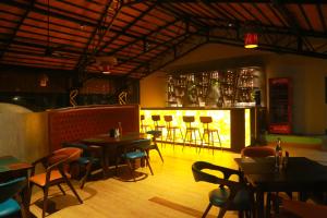 um restaurante com mesas, cadeiras e um bar em DNC Shevaroys Resorts & Spa em Yercaud