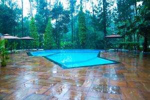a swimming pool in the middle of a patio at DNC Shevaroys Resorts & Spa in Yercaud