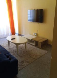 un salon avec une table basse et une télévision dans l'établissement House of Hera, à Kisumu