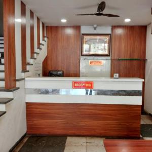 a lobby with a reception counter and stairs at Hotel M S in Pālia