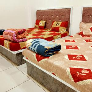two beds sitting next to each other in a room at Hotel M S in Pālia