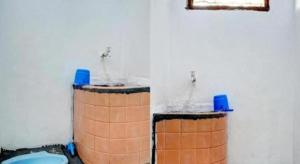 Hotel O Home Stay Syariah Aom Kusman في بلابون راتو: حمام مزود بصنبورين للمياه ومرحاض