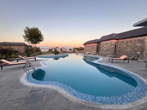 a large pool with blue water in a courtyard at juSTa Luxe Highpoint Jawai in Bijāpur