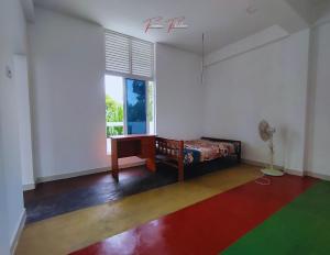 een kamer met een bed, een bureau en een raam bij Prince House in Piliyandala