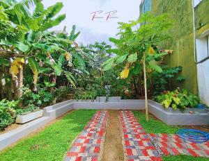 een tuin met een geblokt pad in het gras bij Prince House in Piliyandala