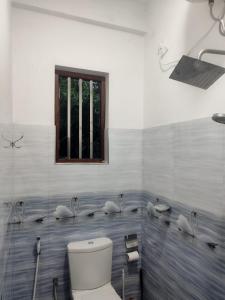 een badkamer met een toilet en een raam bij Prince House in Piliyandala +9 foto's