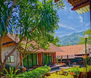 a house with a patio and a palm tree at Phakphing Erawan Homestay - พักพิง เอราวัณ โฮมสเตย์ in Tha Kradan
