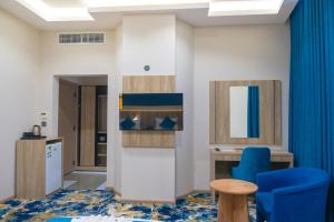 a room with a blue chair and a table at فندق برادايس لاند الشهداء Paradise Land Hotel Al-Shohada in Al ‘Utaybīyah