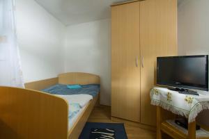 a small bedroom with a bed and a tv at Farm Stay Ferjančič in Vipava