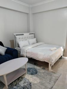 een kamer met twee bedden en een bank en een bank bij Luxe Homes in Meru