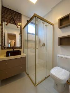 ein Badezimmer mit Dusche, Toilette und Waschbecken in der Unterkunft Apartamento Vó Lêla in Bombinhas