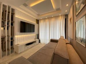 ein Wohnzimmer mit Sofa und Flachbildfernseher in der Unterkunft Apartamento Vó Lêla in Bombinhas